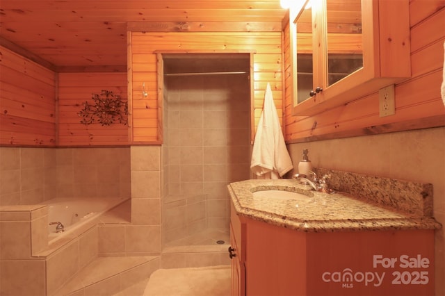 bathroom with vanity, wooden walls, tiled bath, and wooden ceiling