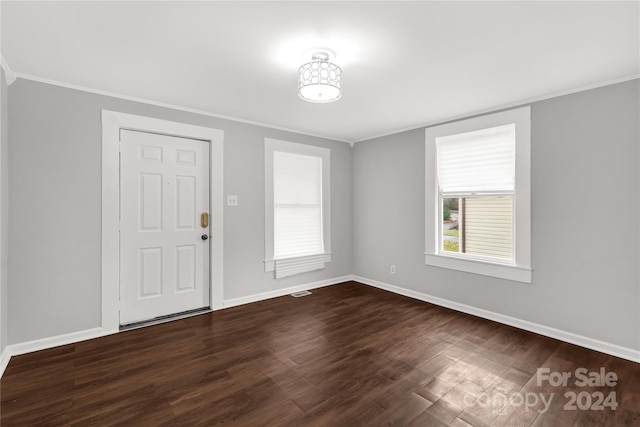 entryway with ornamental molding and dark wood-type flooring