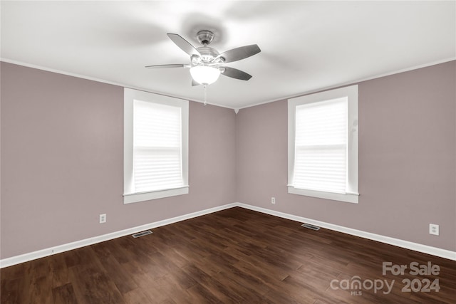 unfurnished room featuring ceiling fan, a healthy amount of sunlight, dark hardwood / wood-style flooring, and crown molding