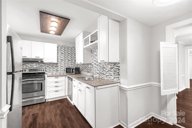 kitchen with white cabinets, sink, decorative backsplash, dark hardwood / wood-style flooring, and stainless steel appliances