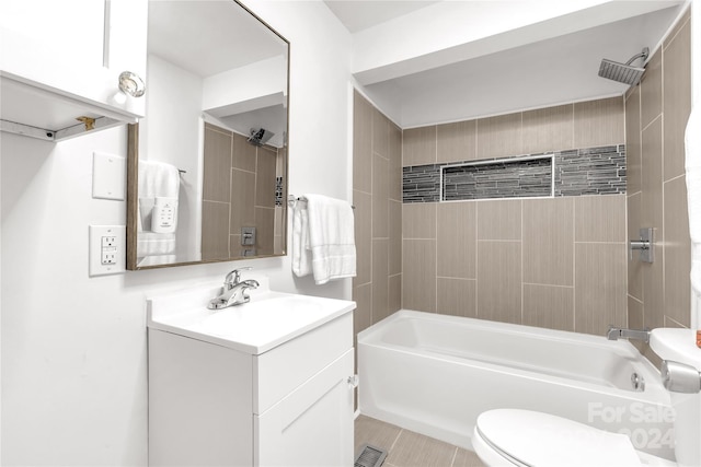 full bathroom featuring tile patterned floors, vanity, toilet, and tiled shower / bath combo