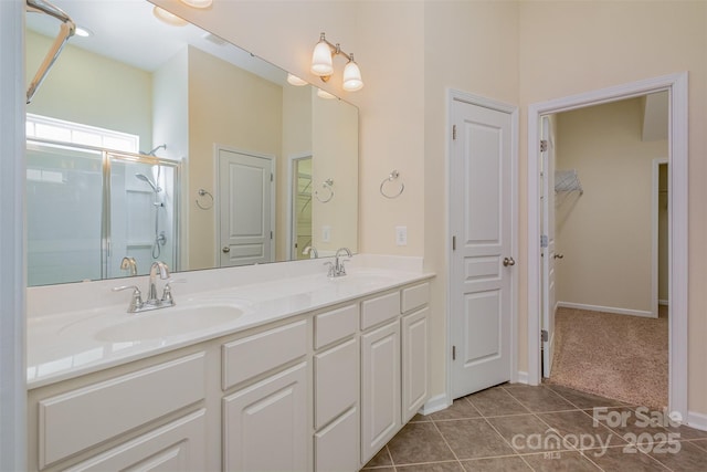 bathroom with tile patterned floors, a shower with door, and vanity