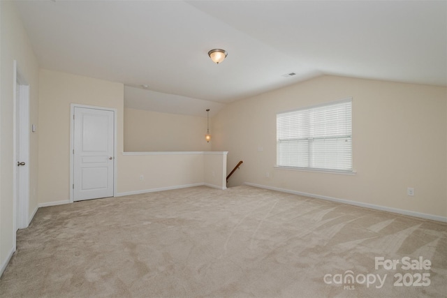 carpeted empty room featuring lofted ceiling