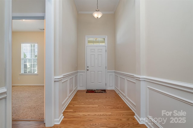 entryway with light hardwood / wood-style flooring and ornamental molding