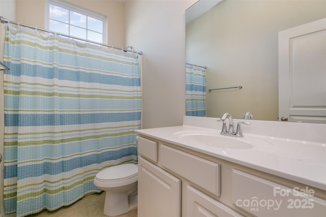 bathroom with tile patterned flooring, vanity, and toilet