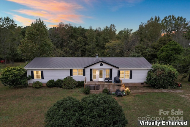 ranch-style home with a yard and a deck