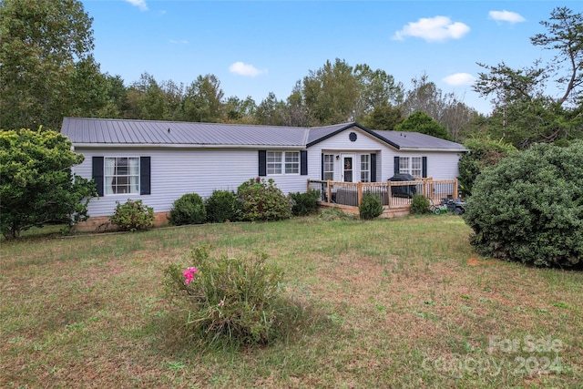 ranch-style house with a front yard and a deck