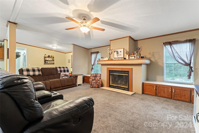 carpeted living room with a fireplace, a textured ceiling, ceiling fan, lofted ceiling, and crown molding