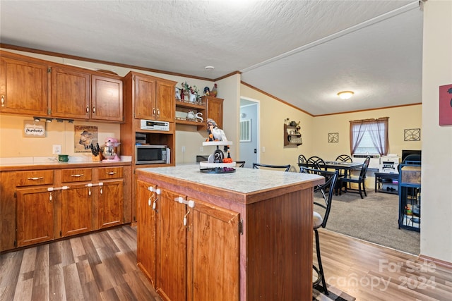 kitchen featuring dark hardwood / wood-style floors, a textured ceiling, lofted ceiling, and a kitchen island