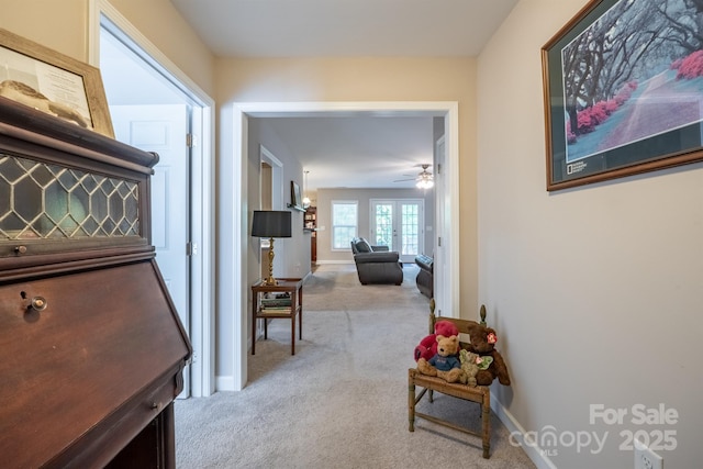 hall featuring carpet flooring and baseboards