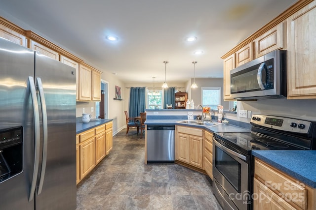 kitchen with dark countertops, light brown cabinetry, a peninsula, stainless steel appliances, and a sink