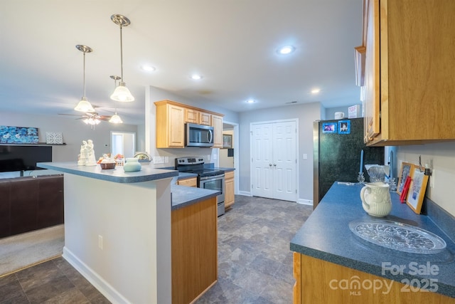 kitchen with dark countertops, open floor plan, recessed lighting, appliances with stainless steel finishes, and a peninsula