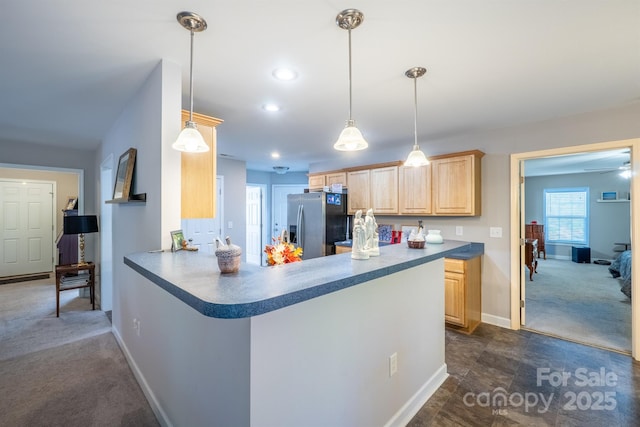 kitchen featuring dark countertops, stainless steel fridge with ice dispenser, light brown cabinets, and dark colored carpet