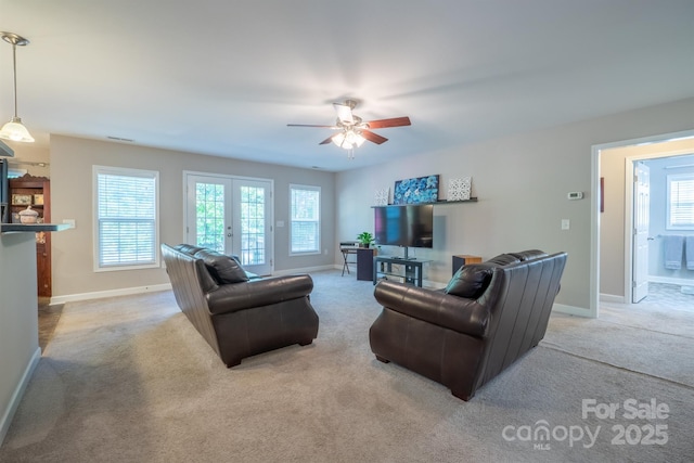 living room featuring french doors, a healthy amount of sunlight, and carpet flooring