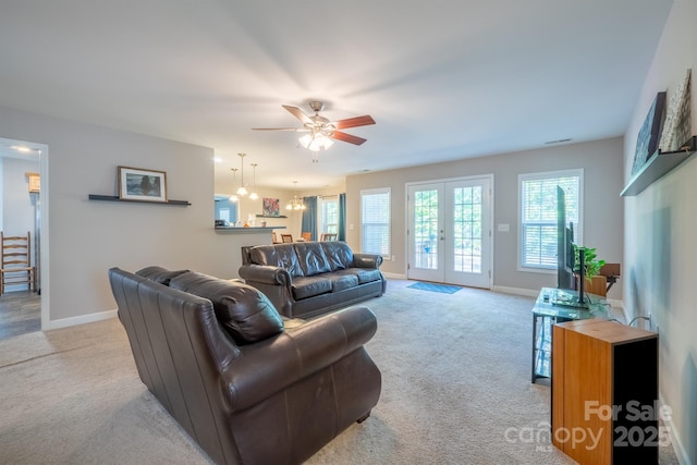 living area featuring light carpet, visible vents, french doors, and baseboards