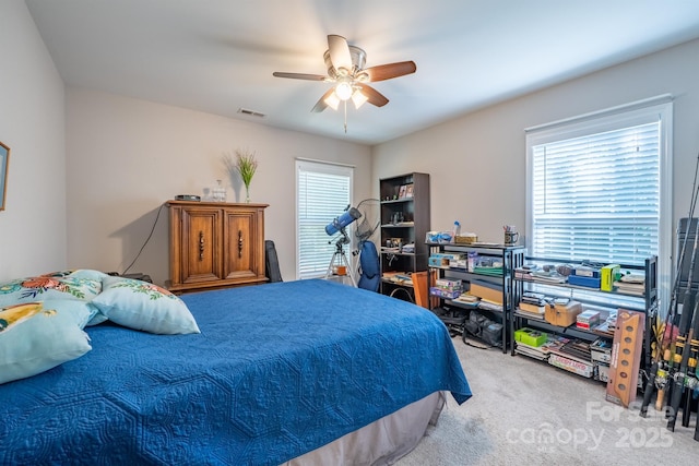 carpeted bedroom featuring visible vents and a ceiling fan