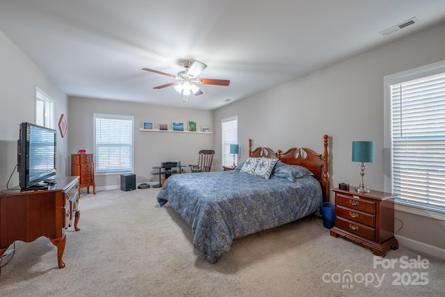 carpeted bedroom featuring visible vents, baseboards, and a ceiling fan