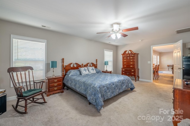 bedroom featuring light carpet, visible vents, ceiling fan, and baseboards