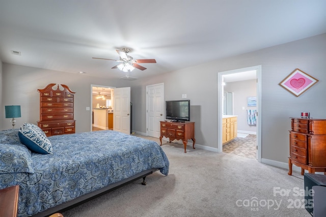 carpeted bedroom with ensuite bath, visible vents, baseboards, and ceiling fan