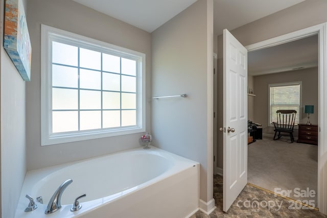 full bathroom featuring a bath and a healthy amount of sunlight