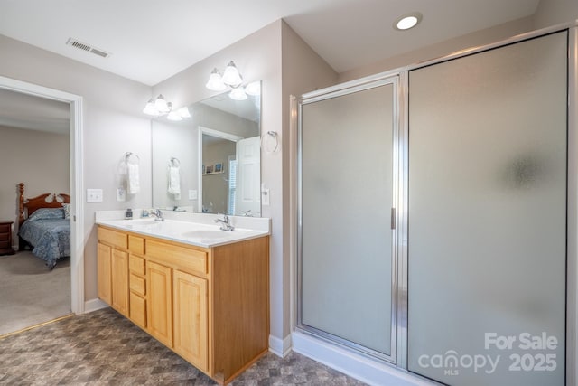 ensuite bathroom with a shower stall, visible vents, and a sink