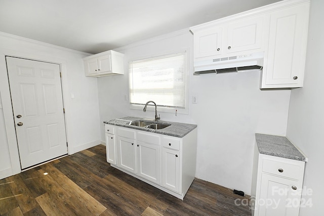 kitchen with sink, ornamental molding, white cabinetry, dark stone countertops, and dark wood-type flooring