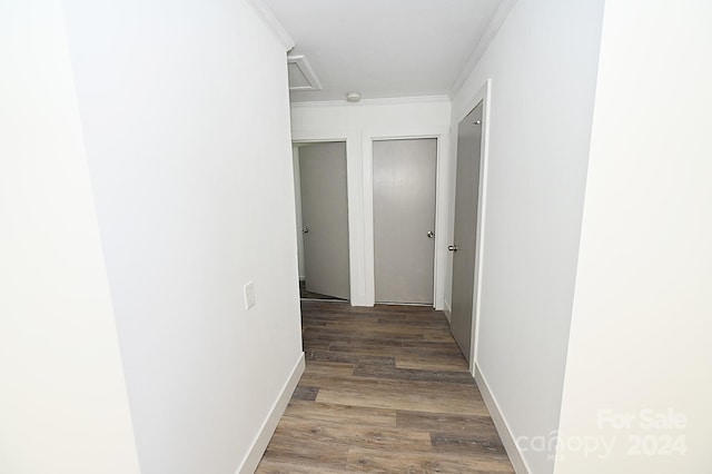 hallway featuring ornamental molding and dark hardwood / wood-style flooring