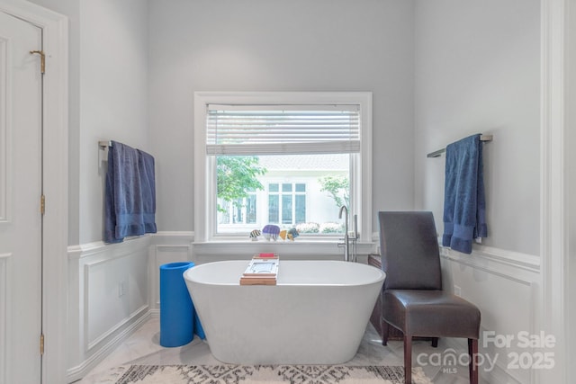 18212 Pompano Pl, Cornelius, NC 28031 - bathroom featuring a wainscoted wall, a freestanding tub, and a decorative wall