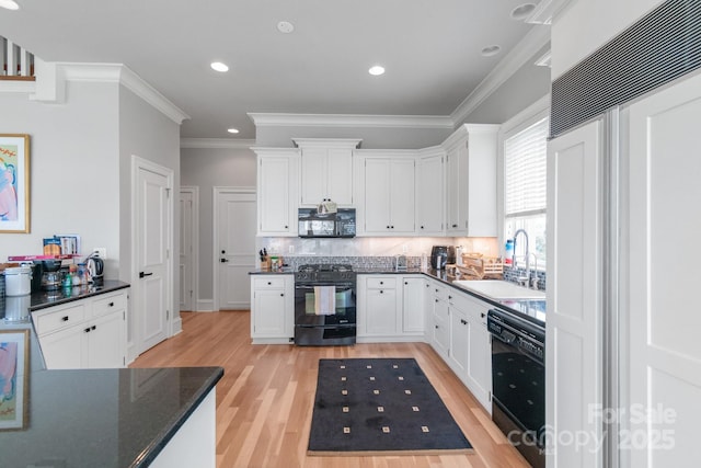 18212 Pompano Pl, Cornelius, NC 28031 - kitchen with black appliances, a sink, light wood-style floors, crown molding, and tasteful backsplash