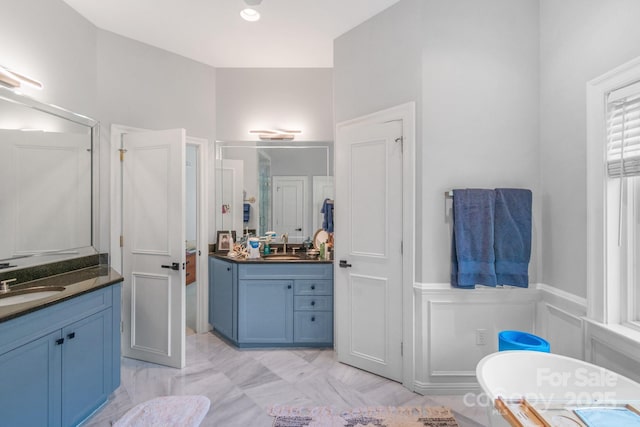 18212 Pompano Pl, Cornelius, NC 28031 - bathroom featuring a freestanding bath, two vanities, a shower stall, and a wainscoted wall