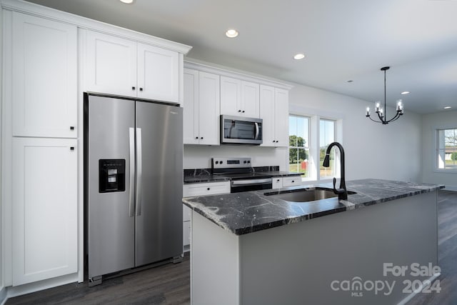 kitchen featuring white cabinets, appliances with stainless steel finishes, a center island with sink, and plenty of natural light