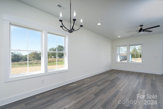 unfurnished dining area featuring ceiling fan with notable chandelier, plenty of natural light, and dark hardwood / wood-style floors