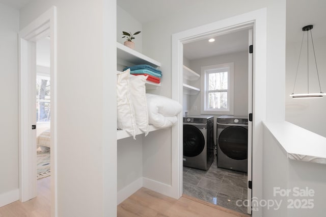 washroom with washer and clothes dryer and light wood-type flooring