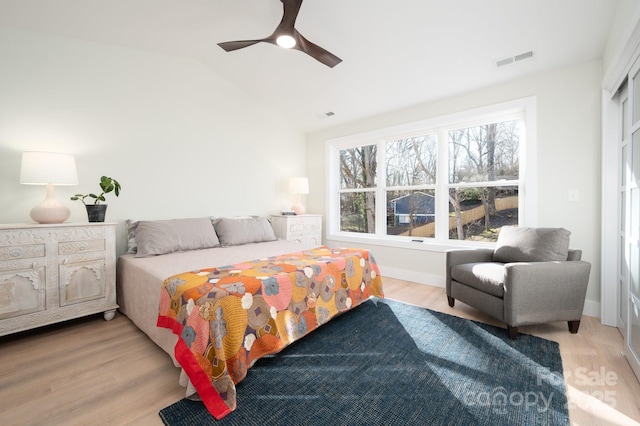 bedroom featuring ceiling fan, light hardwood / wood-style floors, and lofted ceiling