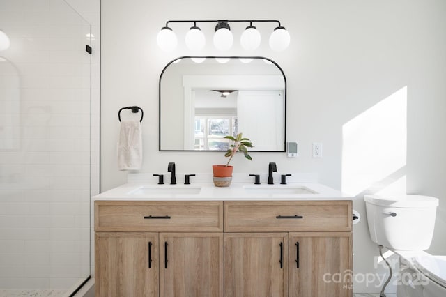 bathroom featuring vanity, toilet, and tiled shower