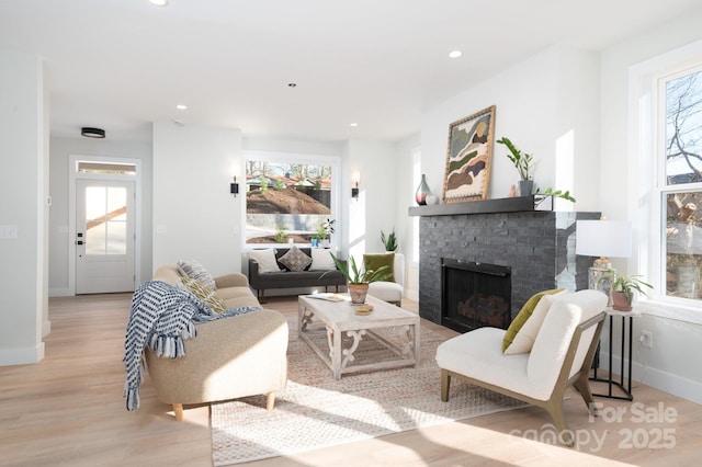 living room with light hardwood / wood-style floors and a brick fireplace