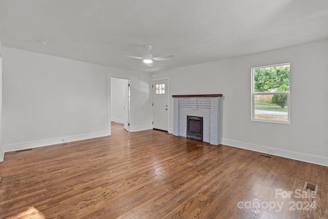 unfurnished living room with a fireplace, wood-type flooring, and ceiling fan