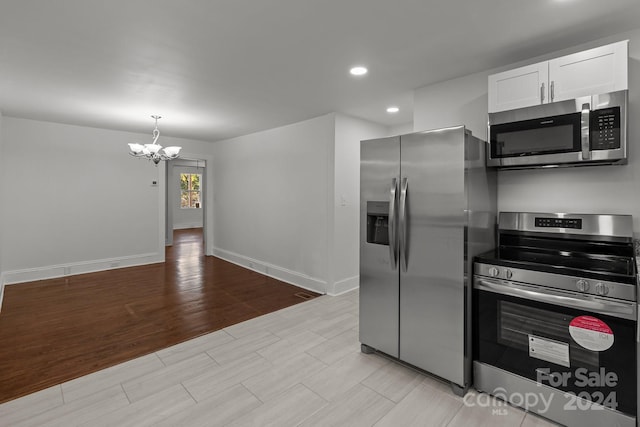 kitchen featuring a chandelier, white cabinetry, decorative light fixtures, and stainless steel appliances