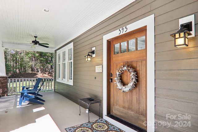 doorway to property featuring ceiling fan and a porch