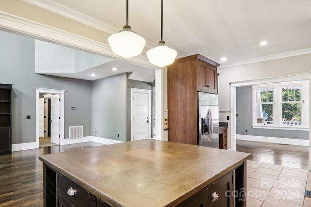 kitchen with crown molding, decorative light fixtures, stainless steel refrigerator with ice dispenser, and dark hardwood / wood-style floors