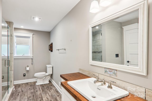 bathroom featuring vanity, wood-type flooring, toilet, and walk in shower