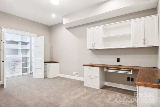 unfurnished office featuring light colored carpet and built in desk