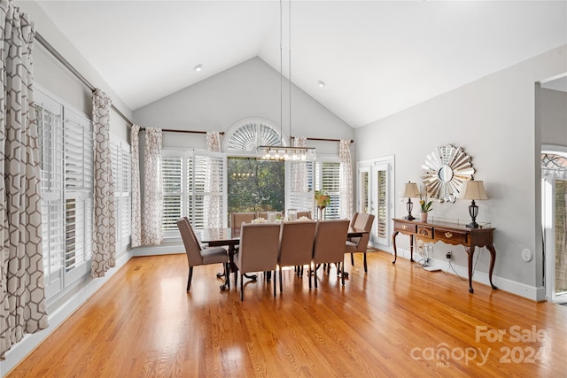 dining space with hardwood / wood-style flooring, high vaulted ceiling, and a wealth of natural light