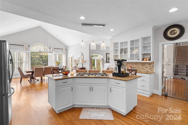 kitchen featuring white cabinets, decorative light fixtures, stainless steel appliances, and light hardwood / wood-style floors