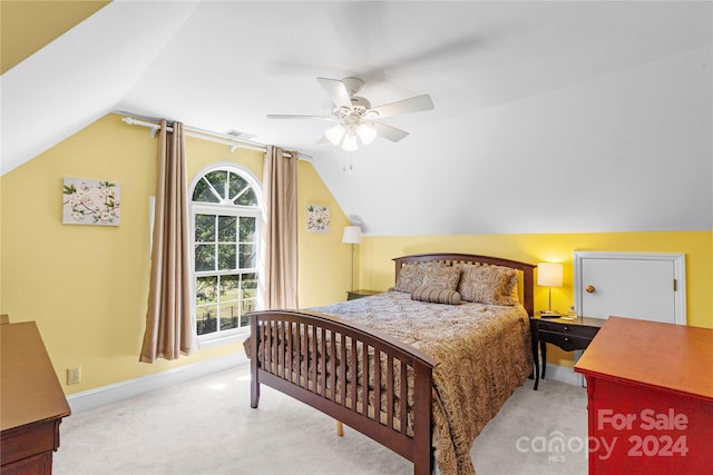 bedroom featuring vaulted ceiling, light colored carpet, and ceiling fan