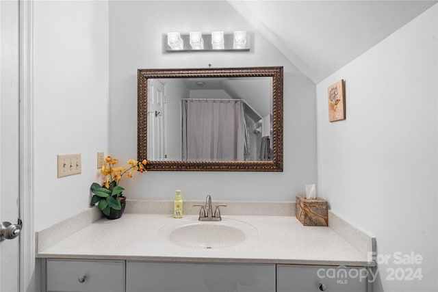 bathroom featuring vanity and lofted ceiling