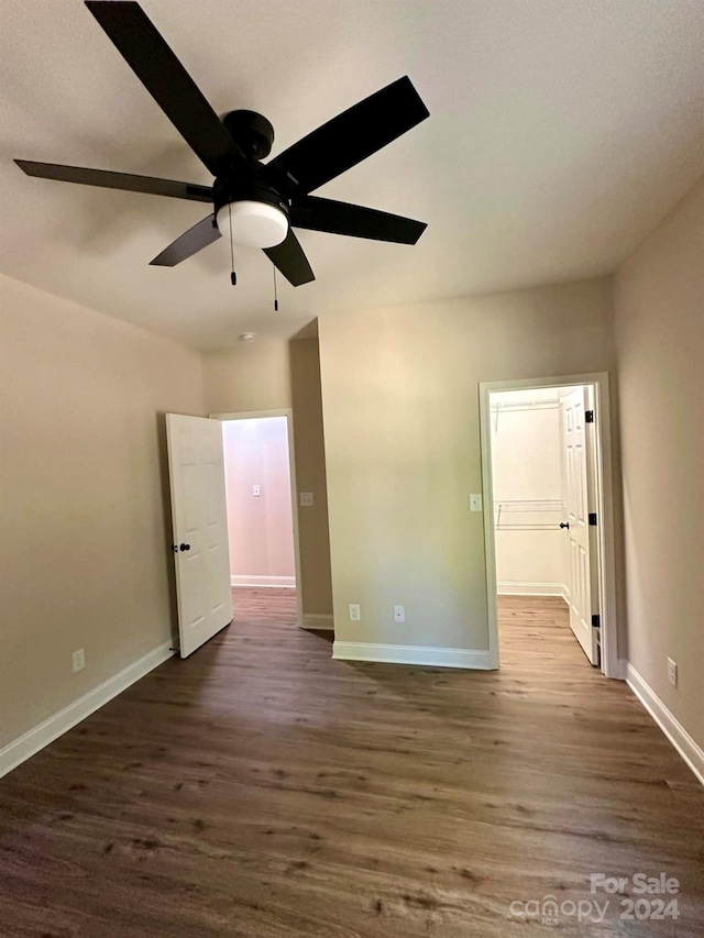 unfurnished room featuring dark wood-type flooring and ceiling fan