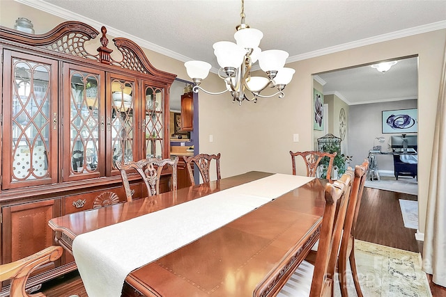 dining area featuring crown molding, a textured ceiling, a chandelier, and wood-type flooring