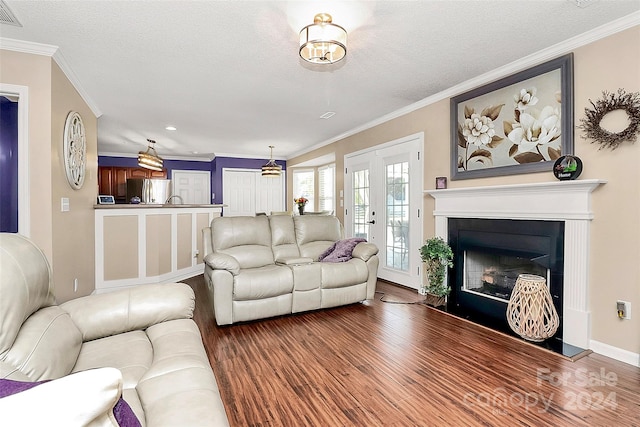 living room with ornamental molding, hardwood / wood-style flooring, and a textured ceiling