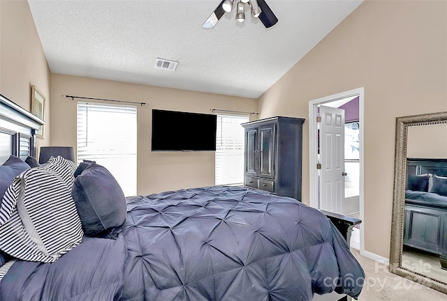 carpeted bedroom with ceiling fan, a textured ceiling, vaulted ceiling, and a fireplace